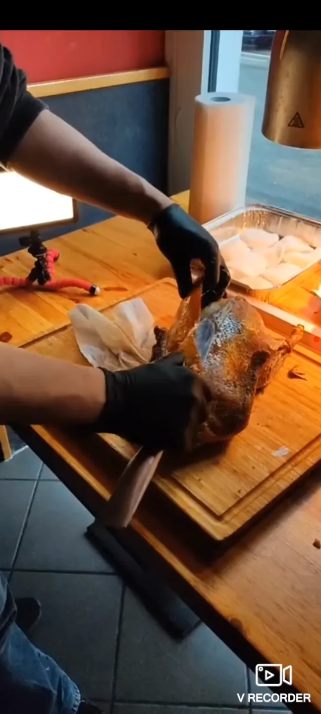 Peking Ente tranchieren Step 7 - Nimm das komplette Stück knusprige Haut vom Rücken heraus. Gegebenenfalls müssen noch Nachschnitte gemacht werden, falls das Fleisch noch am Haut hängt (Video bei 1:50 Minute).